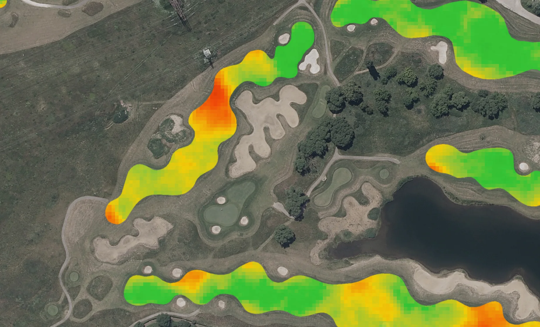 Aerial photo of golf holes beside a lake, fairways coloured by difference from their normal: one dogleg with a red patch, the rest mostly green